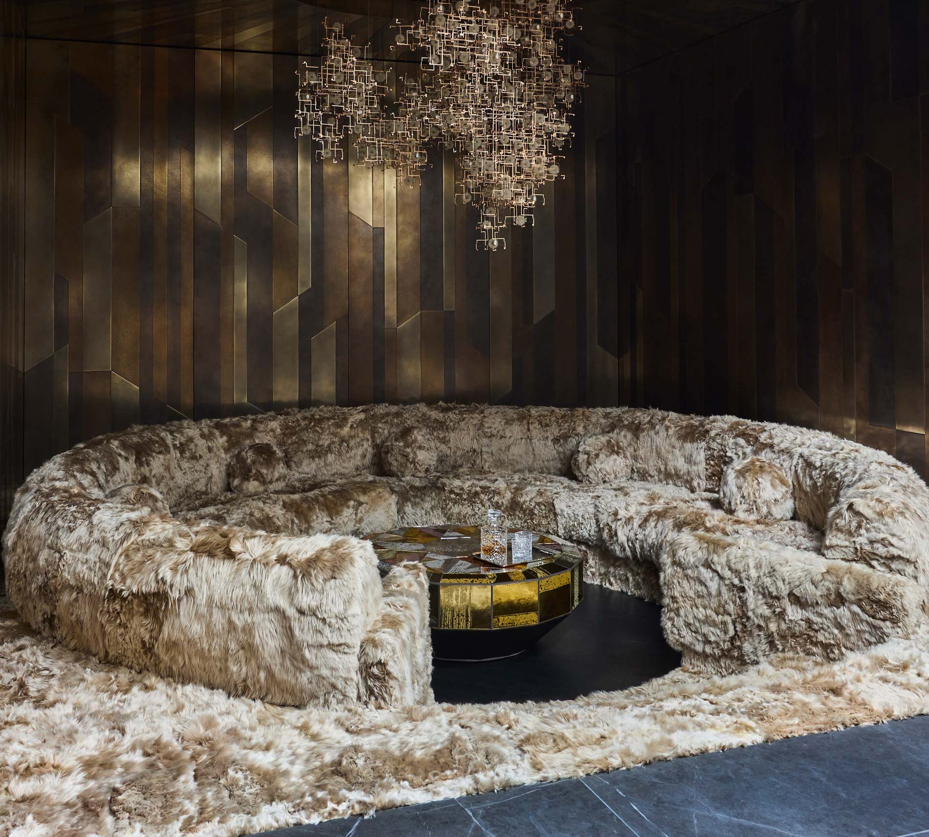 Conversation pit with Alpaca sofa and brass wall panels designed by Trilbey Gordon